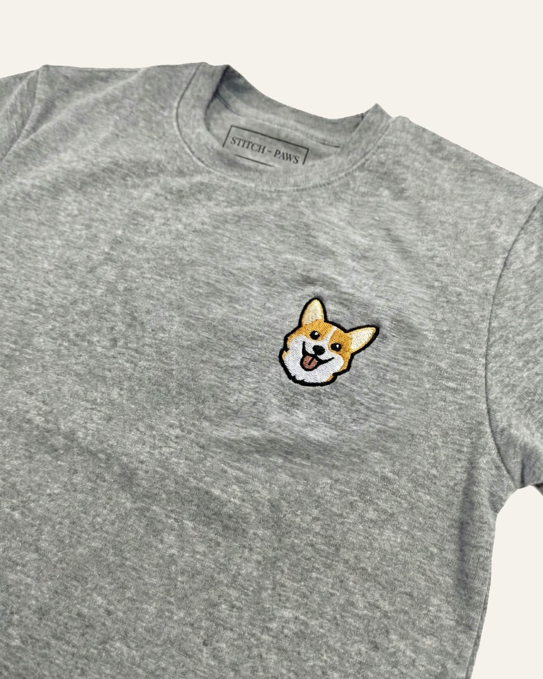 Close up of Light Grey Heather T-shirt with minimalist embroidered Corgi icon on left chest.