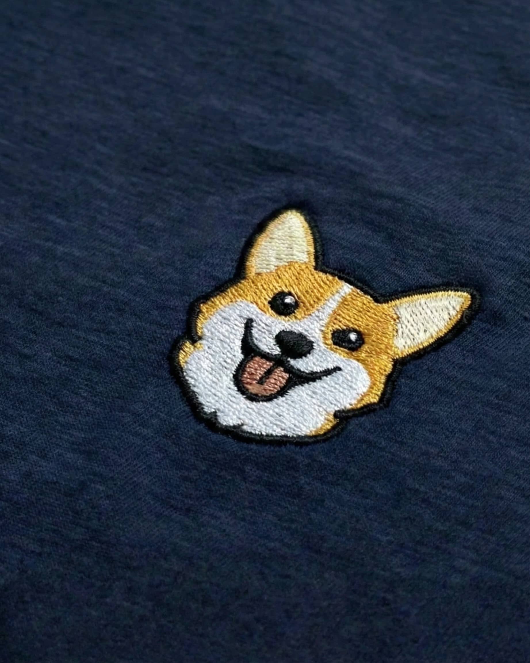 Close-up detail of Corgi embroidery on Navy fabric showing stitch texture.