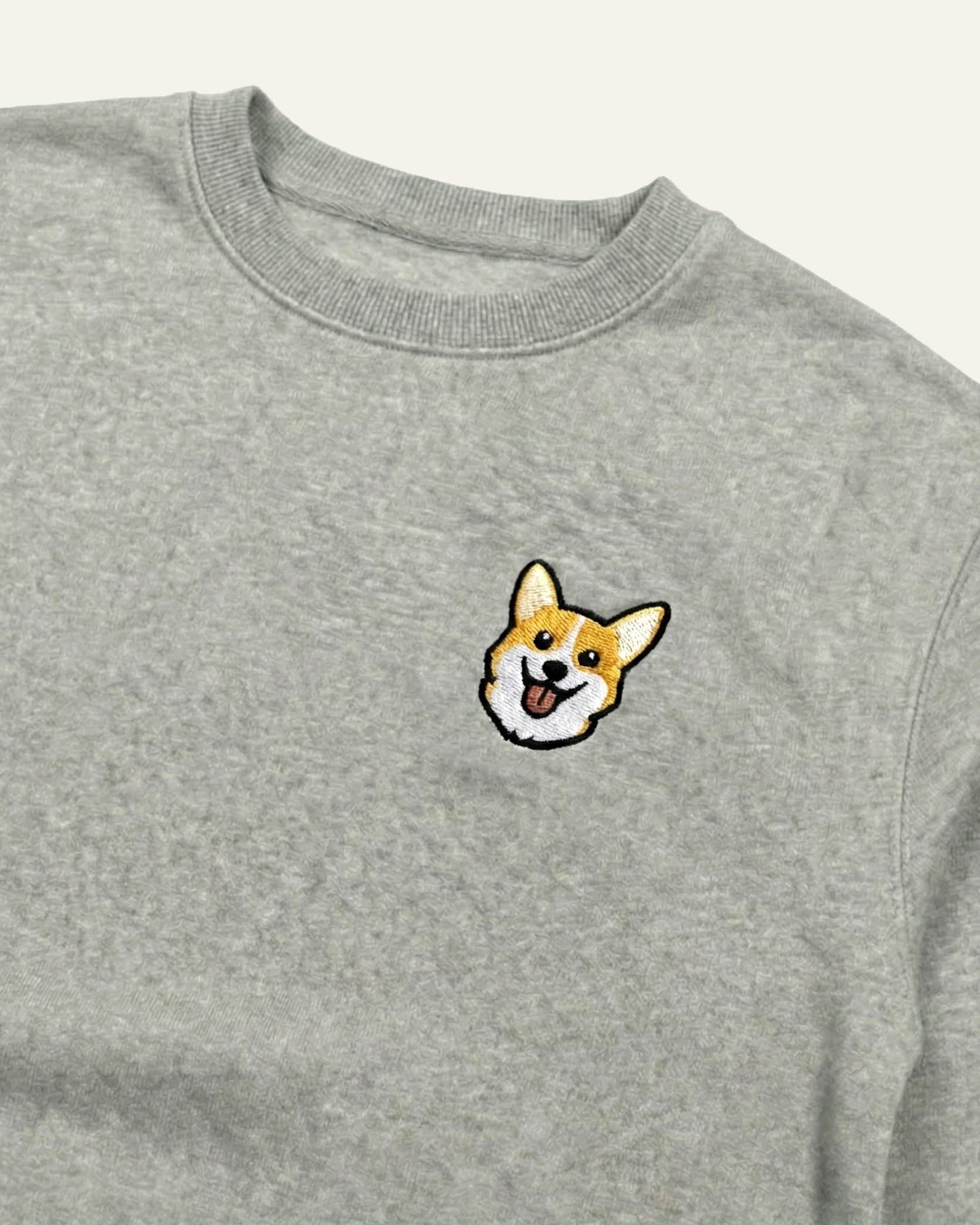 Close up of Light Grey Heather Sweatshirt with minimalist embroidered Corgi icon on left chest.