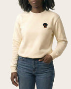 Woman wearing Light Beige Sweatshirt with minimalist embroidered Dachshund icon on left chest.