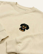 Light Beige Sweatshirt with minimalist embroidered Dachshund icon on left chest.