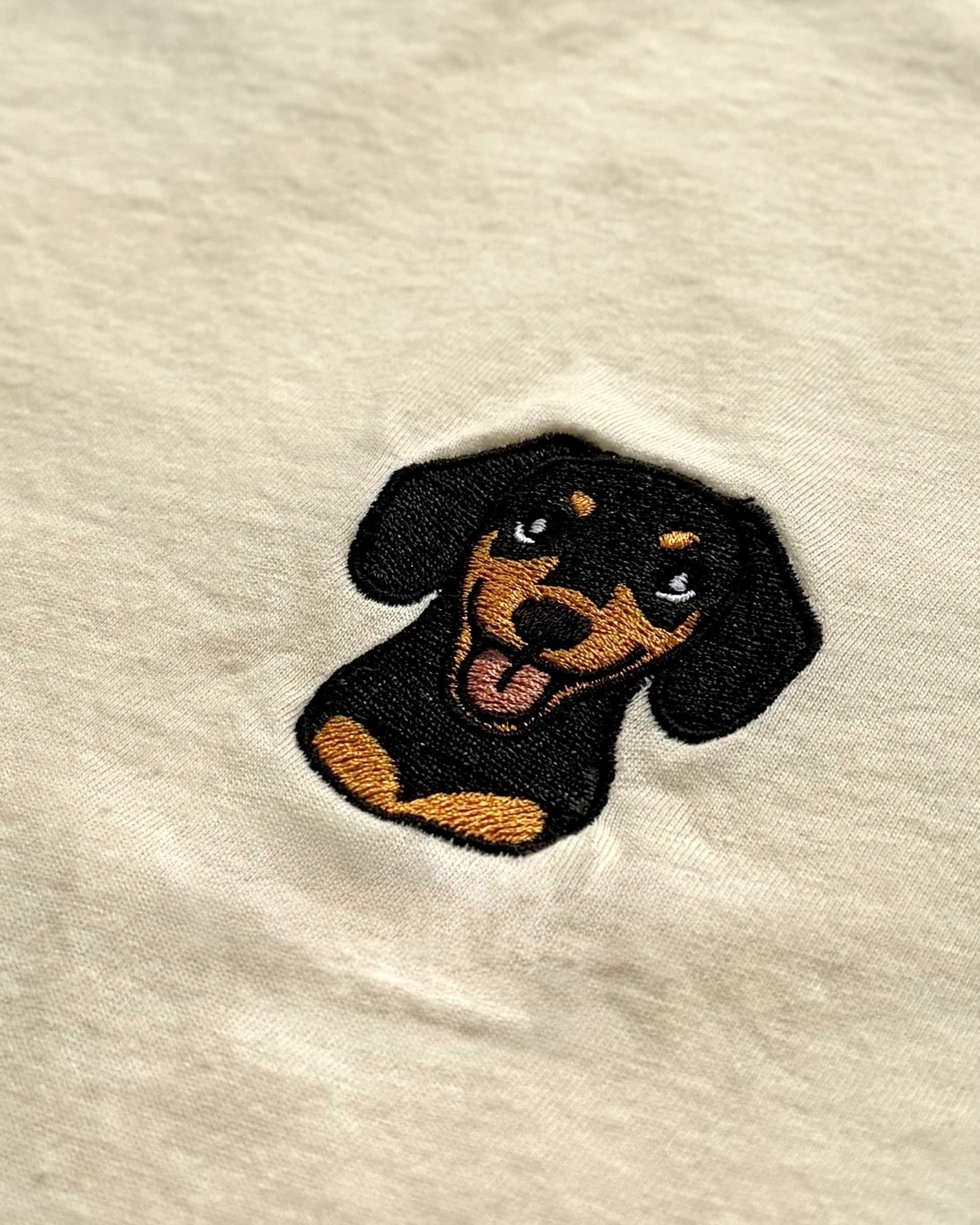 Close-up detail of Dachshund embroidery on Light Beige fabric showing stitch texture.