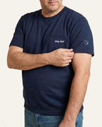 Man wearing Navy t-shirt with minimalist embroidered phrase "dog dad" on left chest. Embroidered Heart and Paw icon on the left sleeve above cuff.