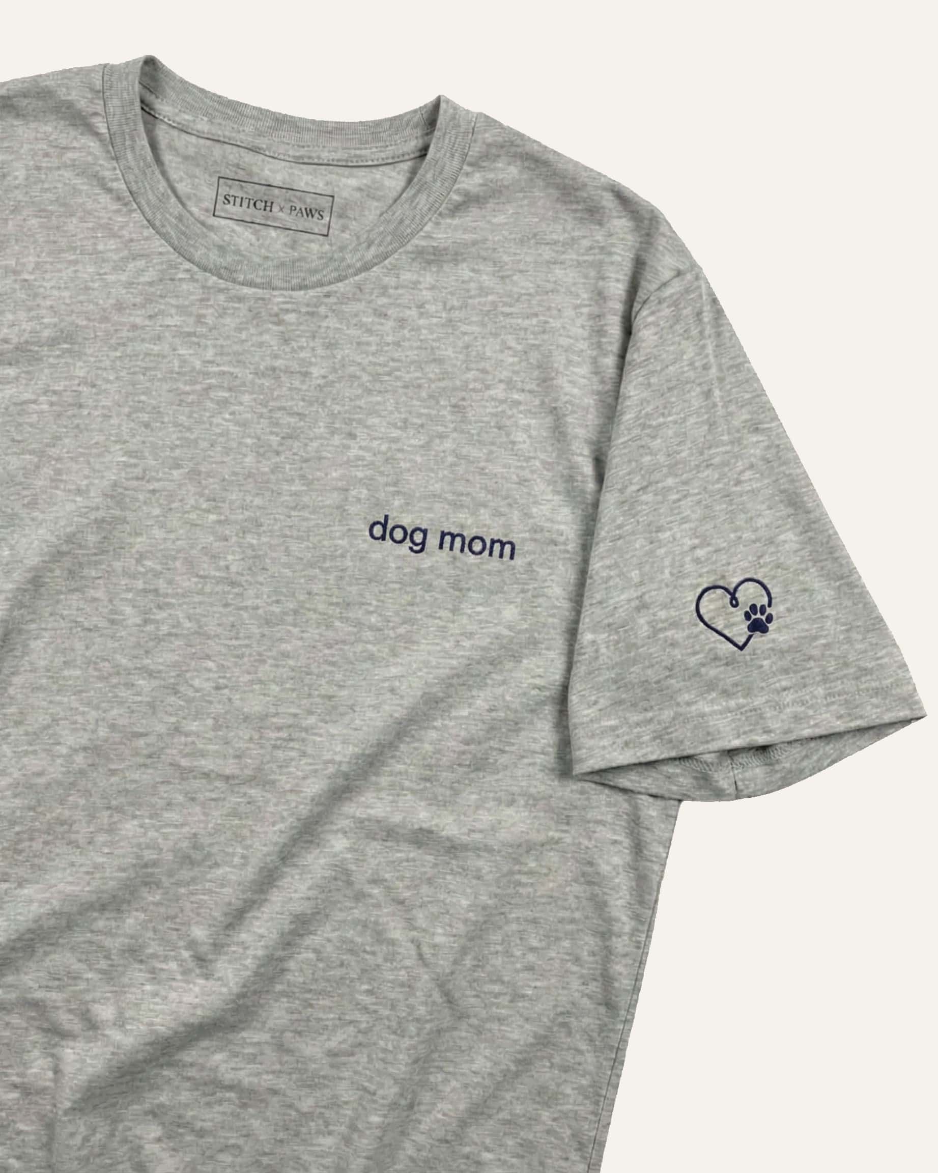 Light Grey Heather t-shirt with minimalist embroidered phrase "dog mom" on left chest. Embroidered Heart and Paw icon on the left sleeve above cuff.