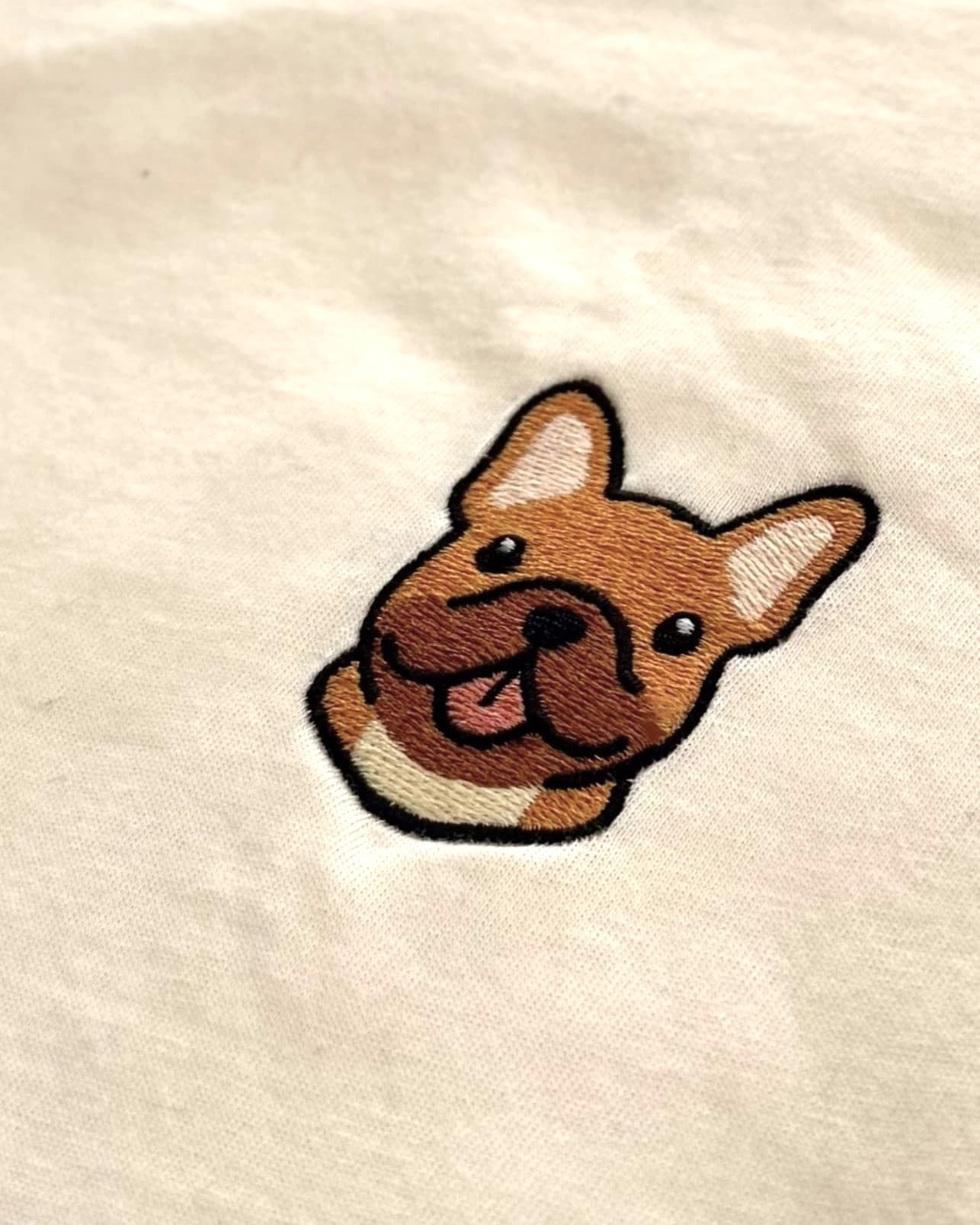 Close-up detail of #fawn Frenchie embroidery on Light Beige fabric showing stitch texture.