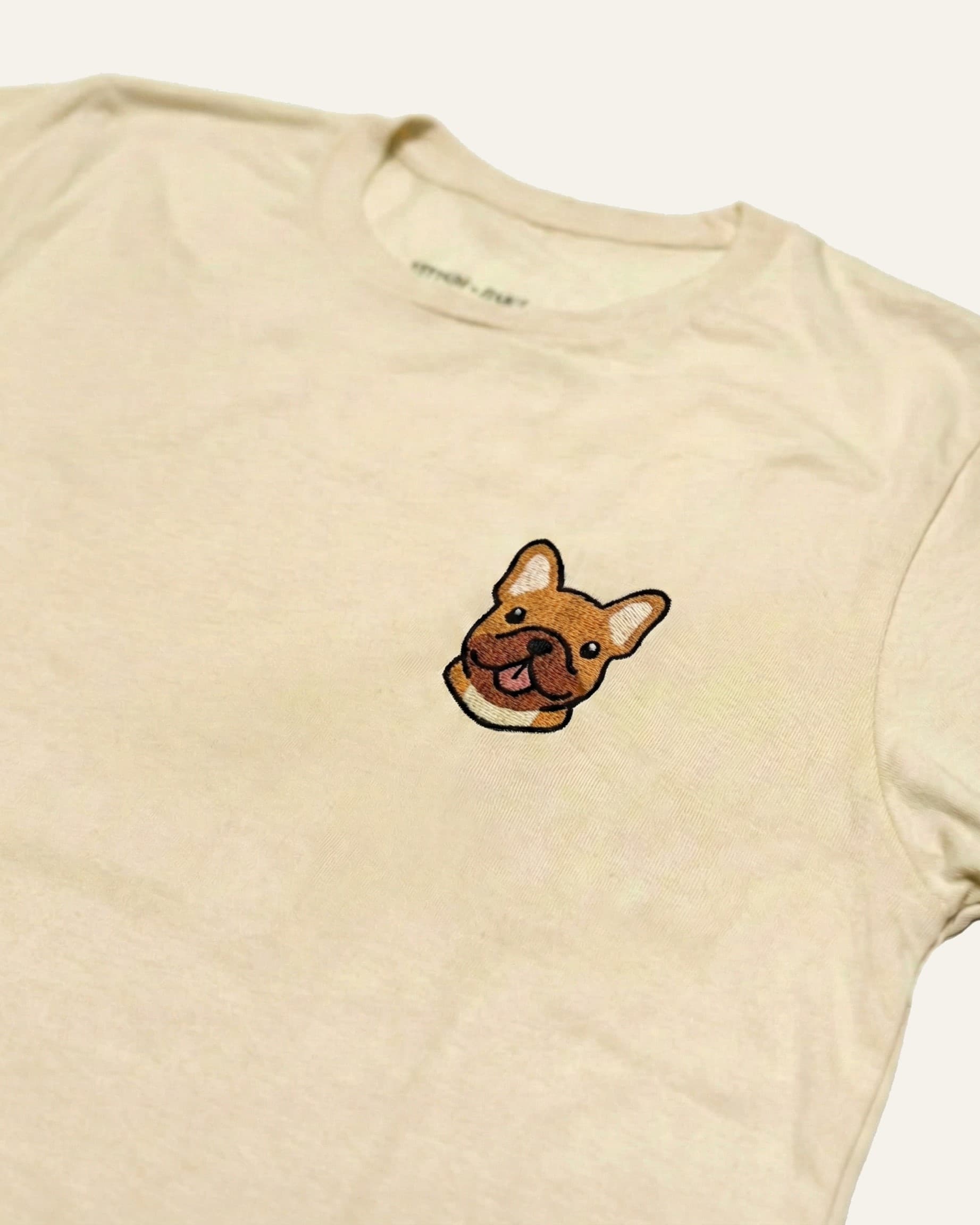 Close up of Beige T-shirt with minimalist embroidered #fawn Frenchie icon on left chest.