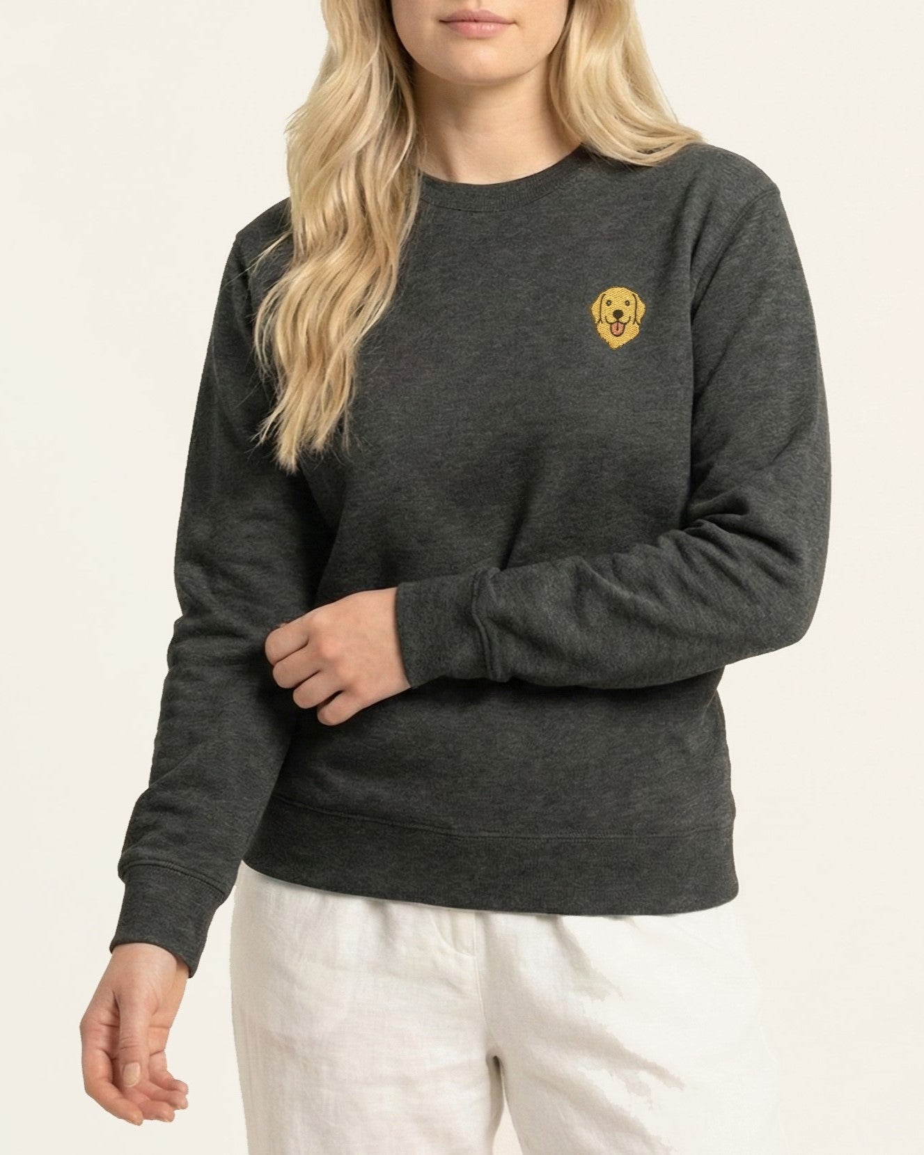 Woman wearing Dark Grey Heather Sweatshirt with minimalist embroidered Golden Retriever icon on left chest.