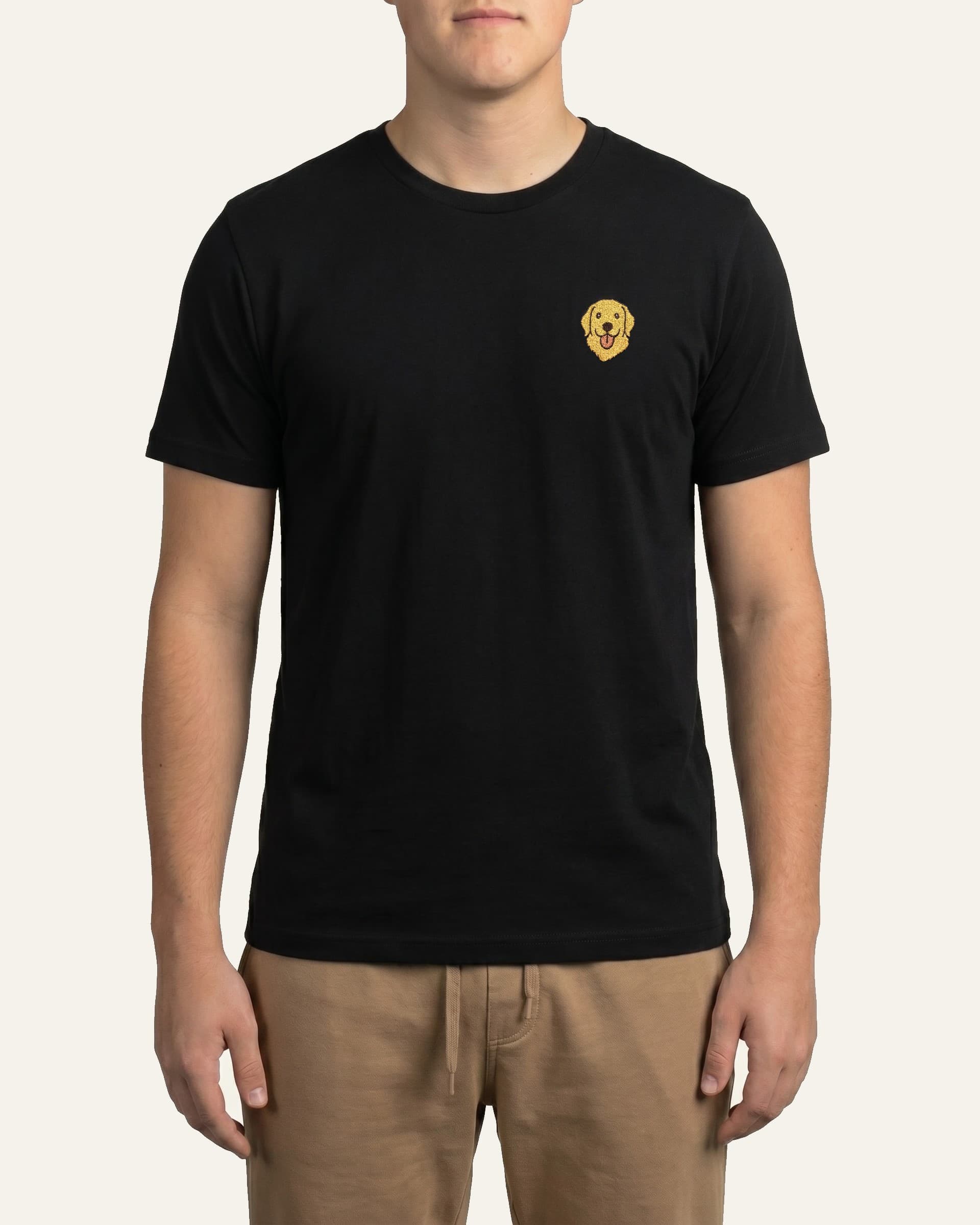 Man wearing Black T-shirt with minimalist embroidered Golden Retriever icon on left chest.