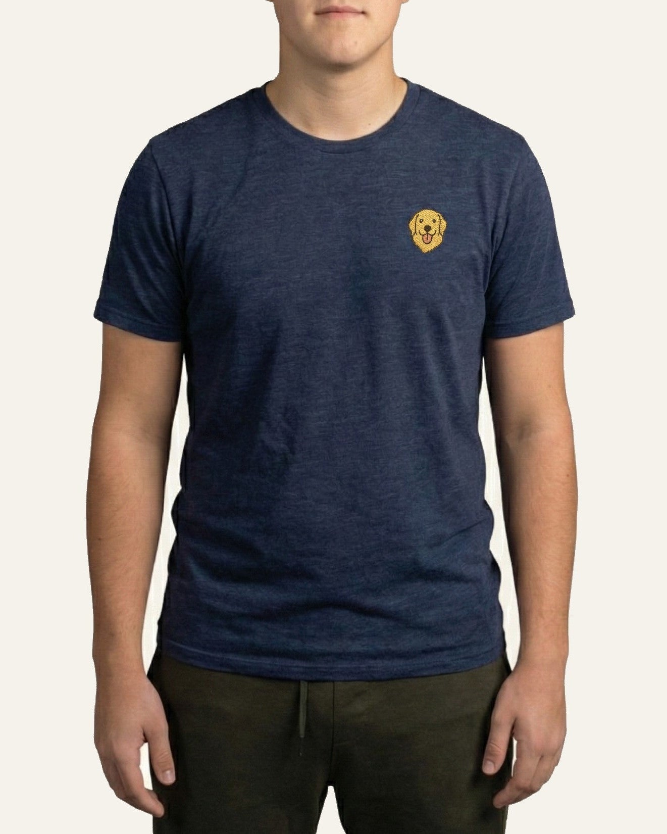 Man wearing Midnight Navy Heather T-shirt with minimalist embroidered Golden Retriever icon on left chest.