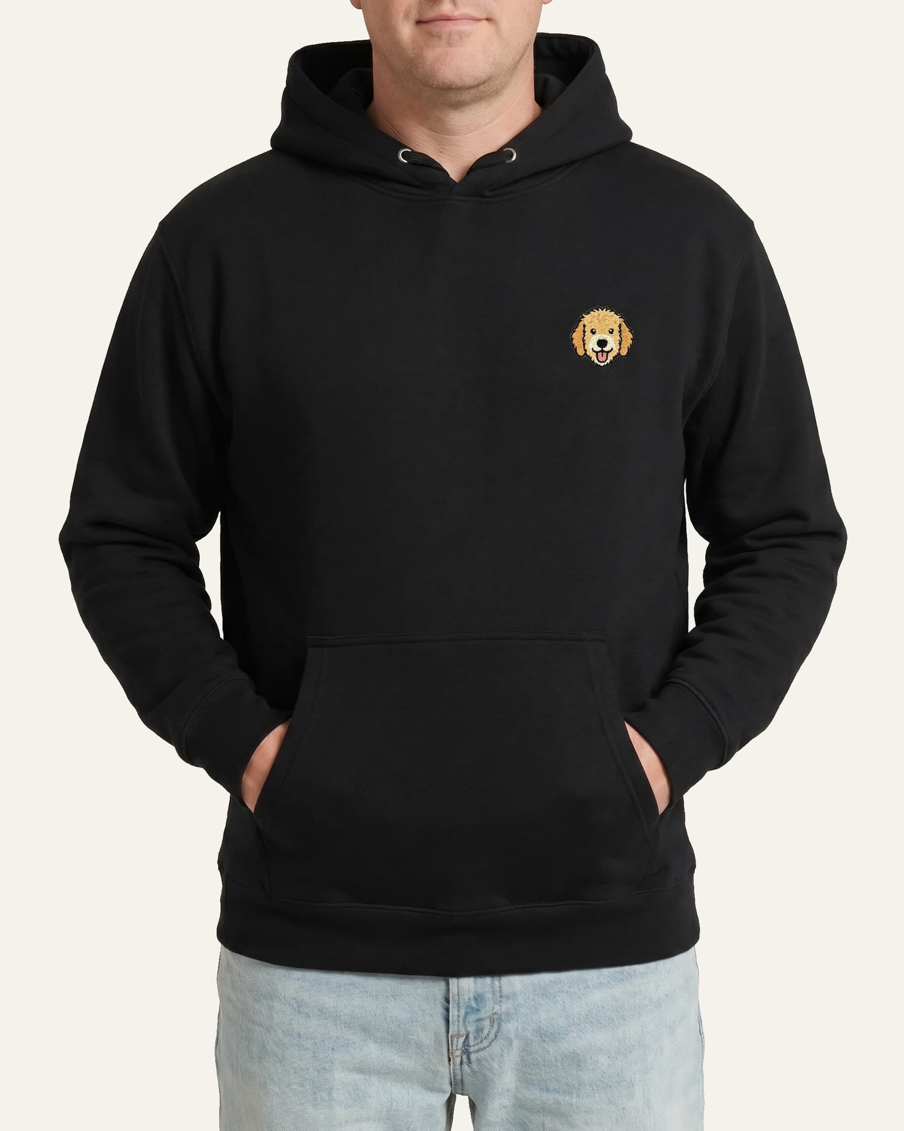 Man wearing Black Hoodie with minimalist embroidered Goldendoodle icon on left chest.