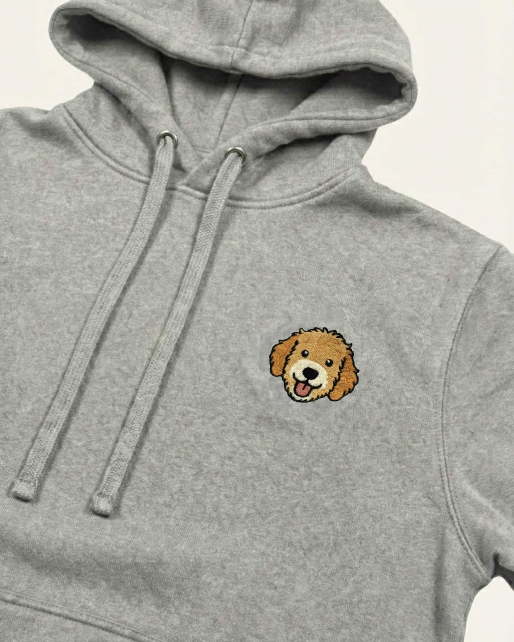 Close up of Light Grey Heather Hoodie with minimalist embroidered Goldendoodle icon on left chest.