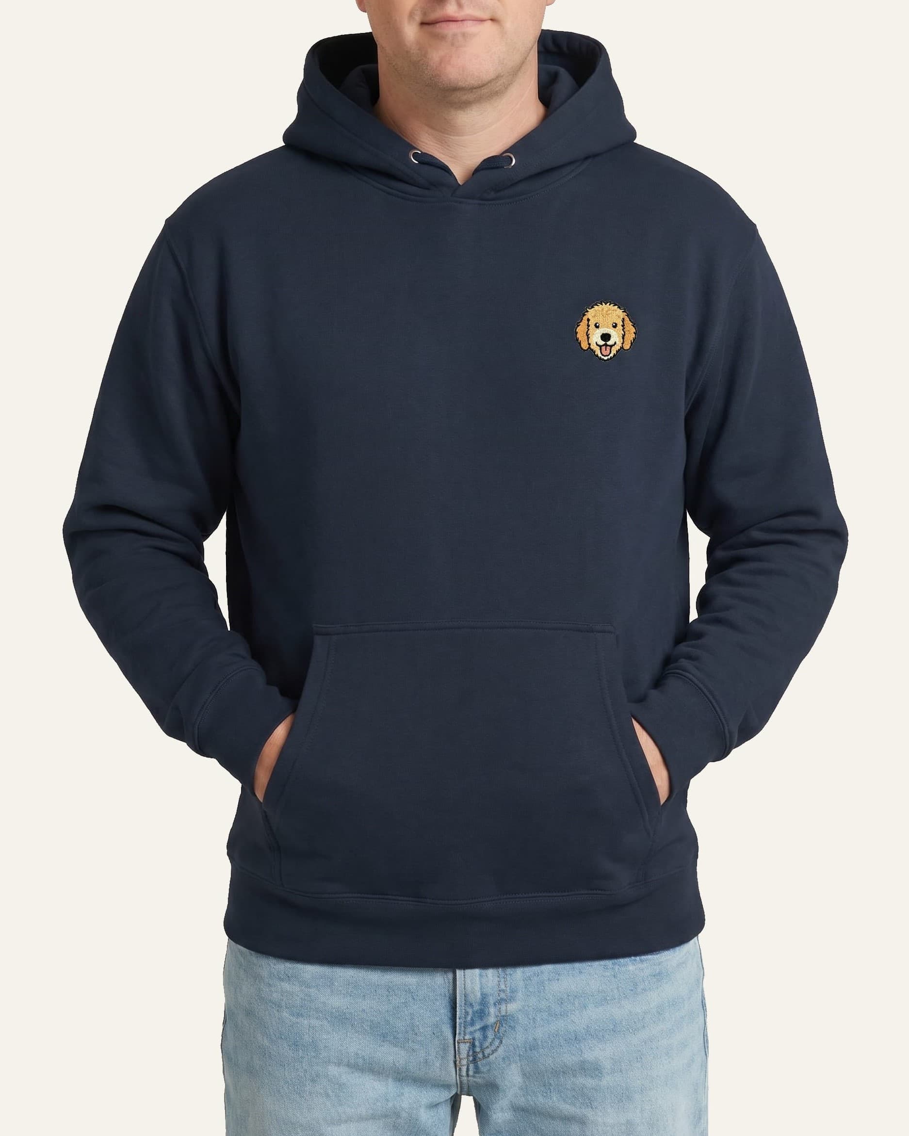 Man wearing Navy Hoodie with minimalist embroidered Goldendoodle icon on left chest.