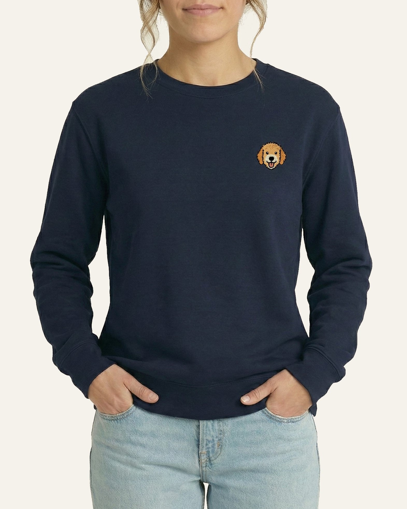 Woman wearing Navy Sweatshirt with minimalist embroidered Goldendoodle icon on left chest.
