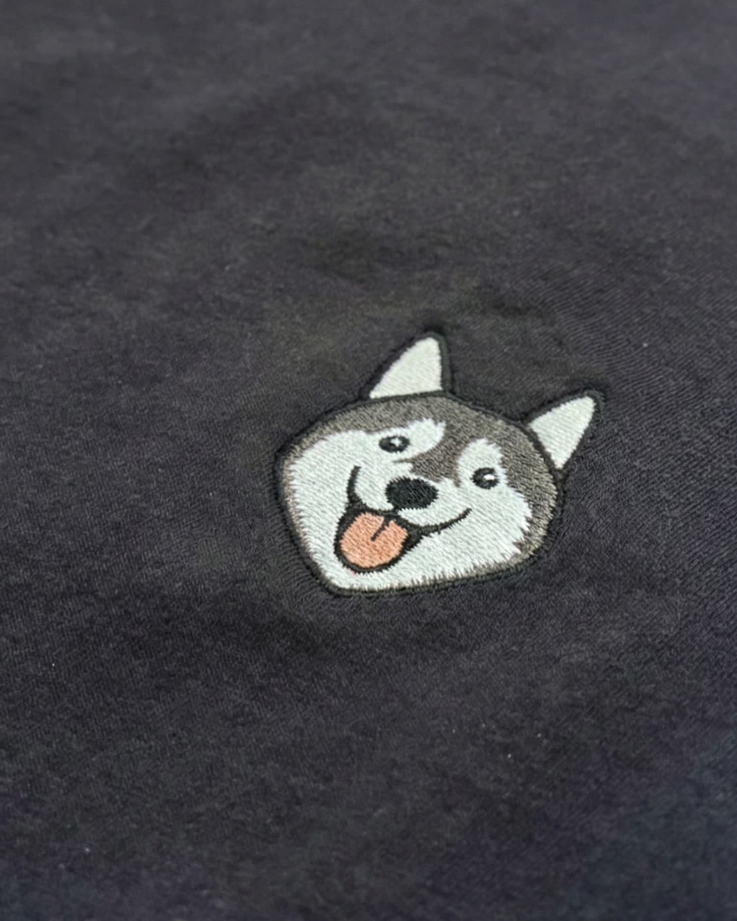 Close-up detail of Husky embroidery on Black fabric showing stitch texture.