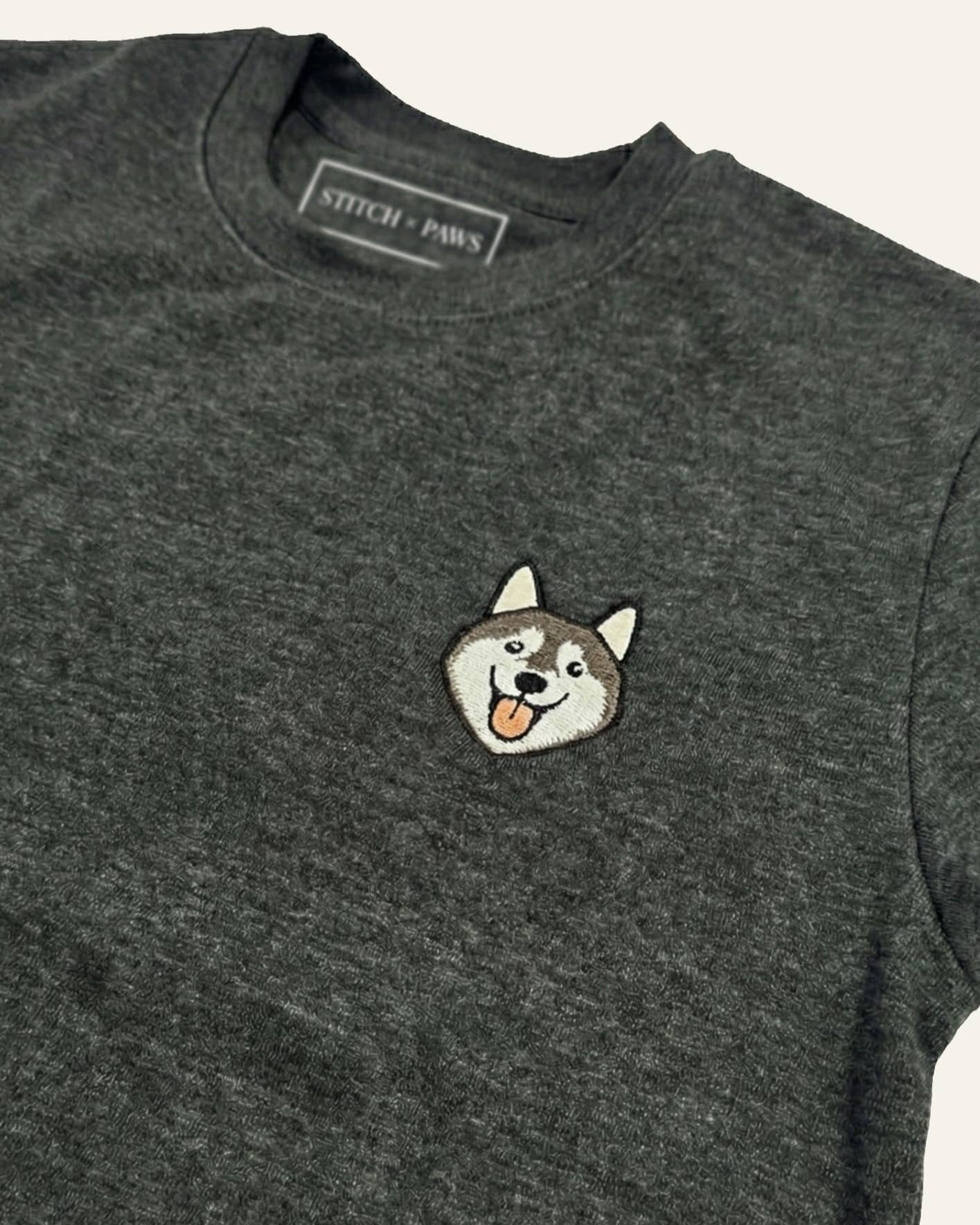 Dark Grey Heather Sweatshirt with minimalist embroidered Husky icon on left chest.