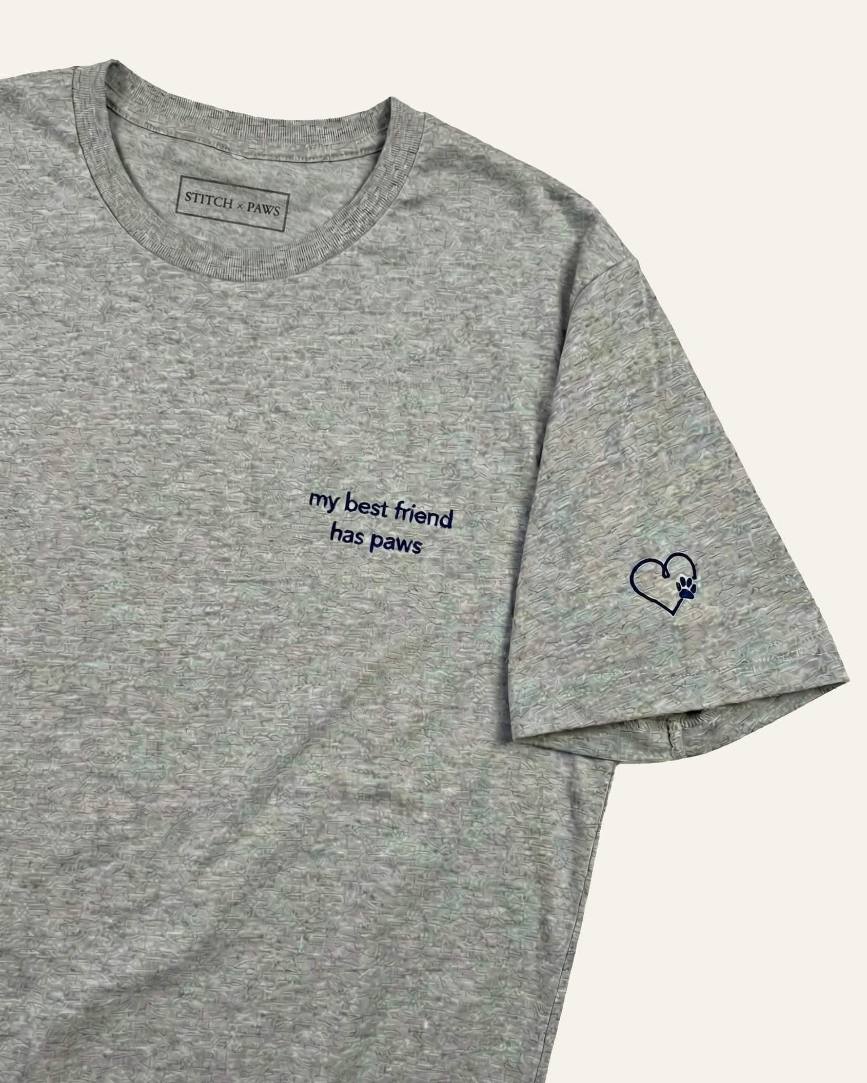 Light Grey Heather  t-shirt with minimalist embroidered phrase "my best friend has paws" on left chest. Embroidered Heart and Paw icon on the left sleeve above cuff.