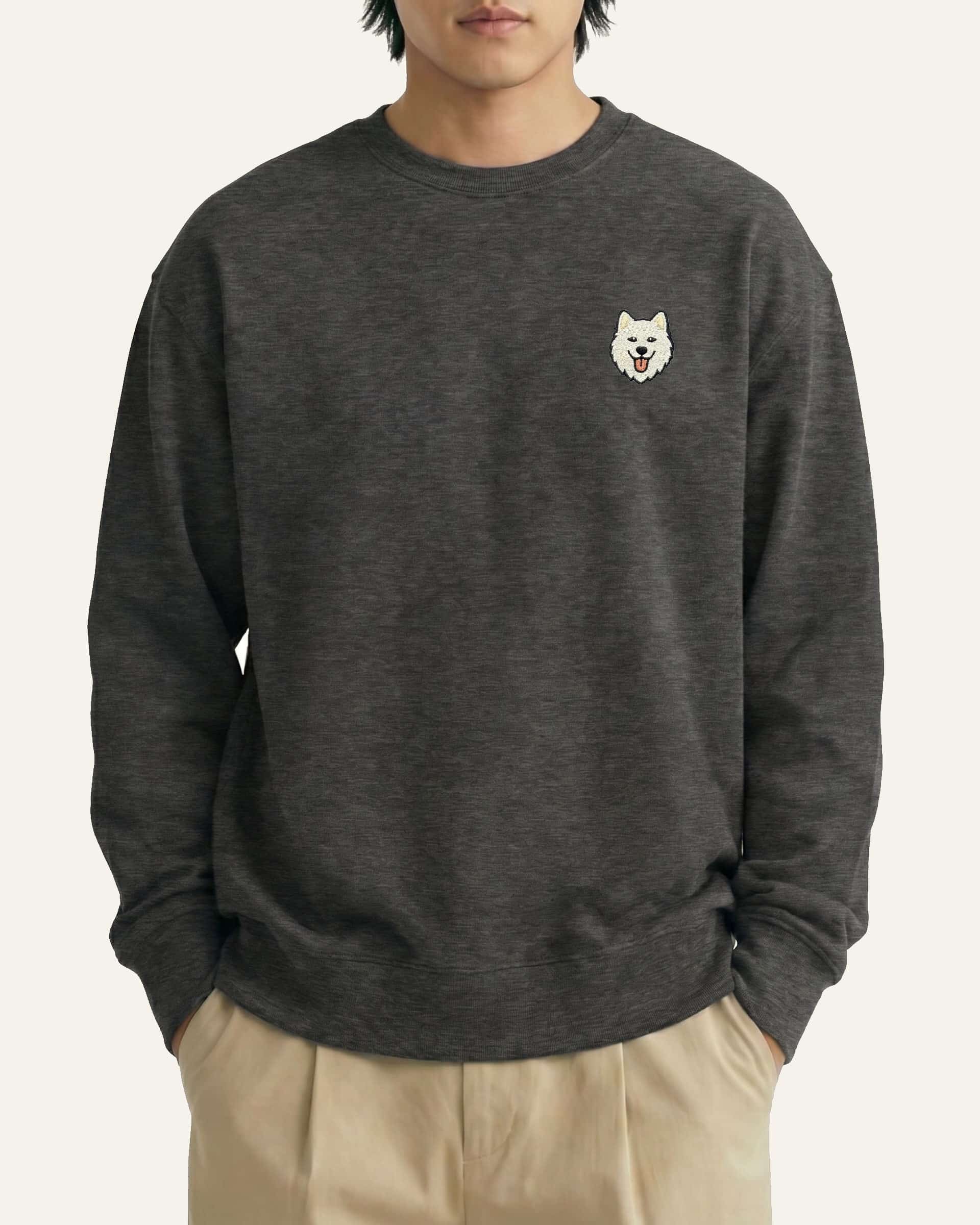 Man wearing Dark Grey Heather Sweatshirt with minimalist embroidered Samoyed icon on left chest.