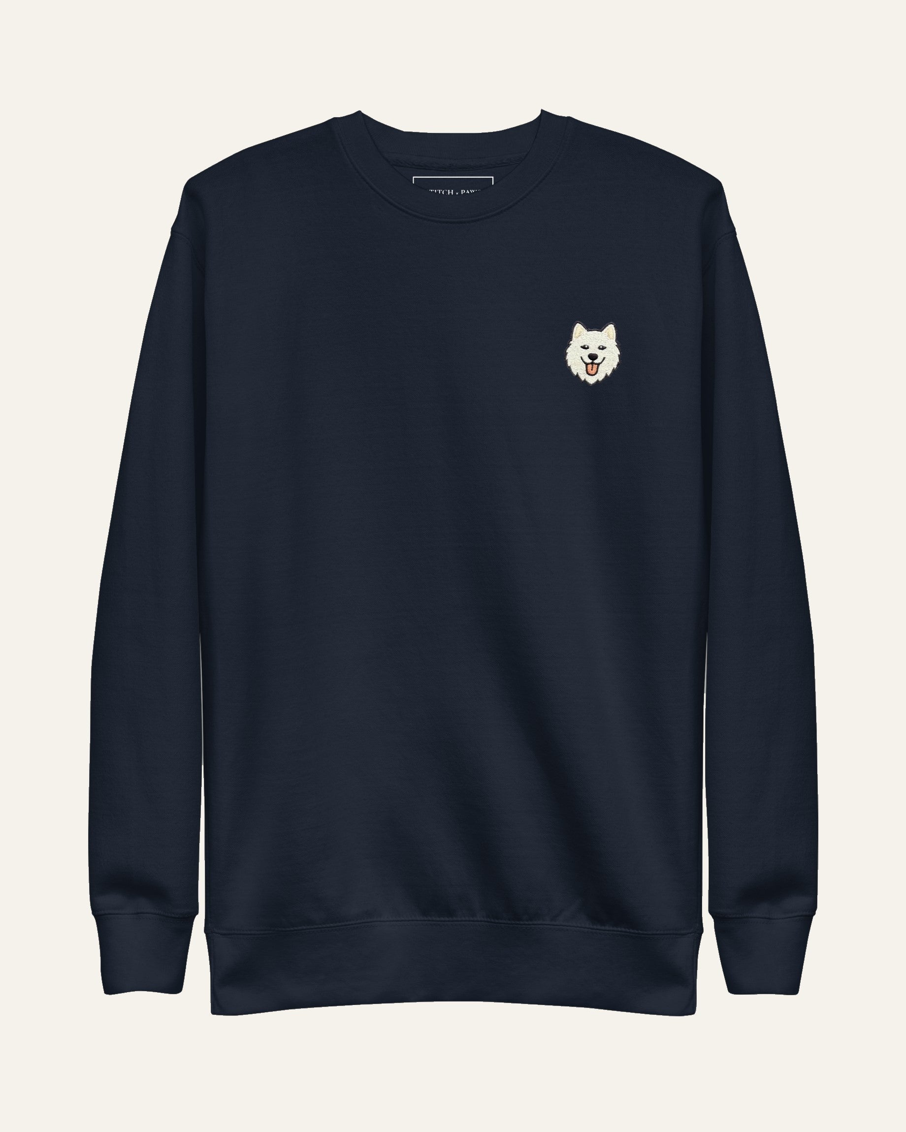 Navy Sweatshirt with minimalist embroidered Samoyed icon on left chest.