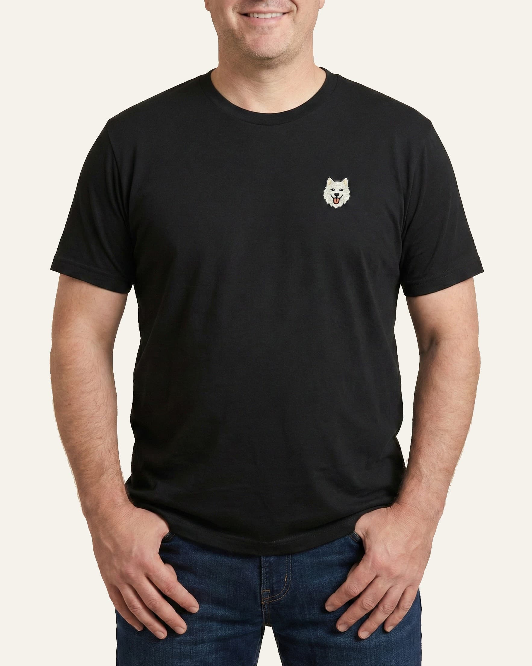 Man wearing Black T-shirt with minimalist embroidered Samoyed icon on left chest.