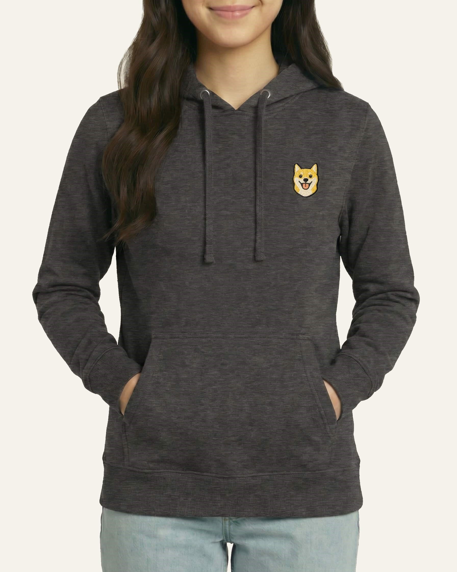 Woman wearing Dark Grey Heather Hoodie with minimalist embroidered Shiba Inu icon on left chest.