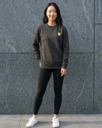 Woman wearing Dark Grey Heather Sweatshirt with minimalist embroidered Shiba Inu icon on left chest.
