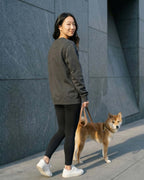 Woman wearing Dark Grey Heather Sweatshirt walking Shiba Inu.