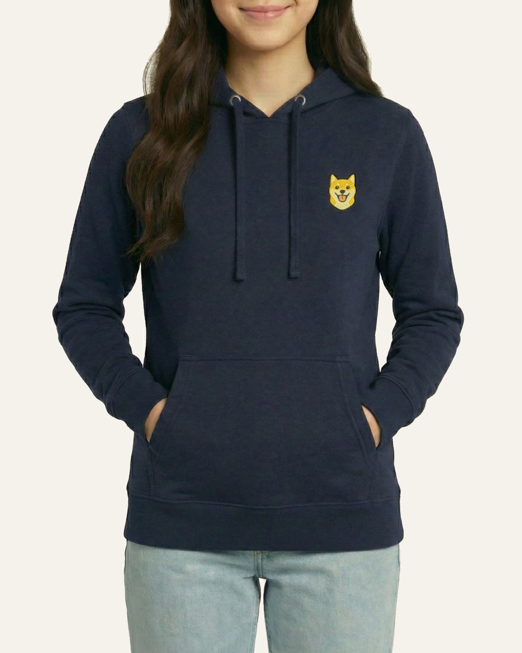 Woman wearing Navy Hoodie with minimalist embroidered Shiba Inu icon on left chest.