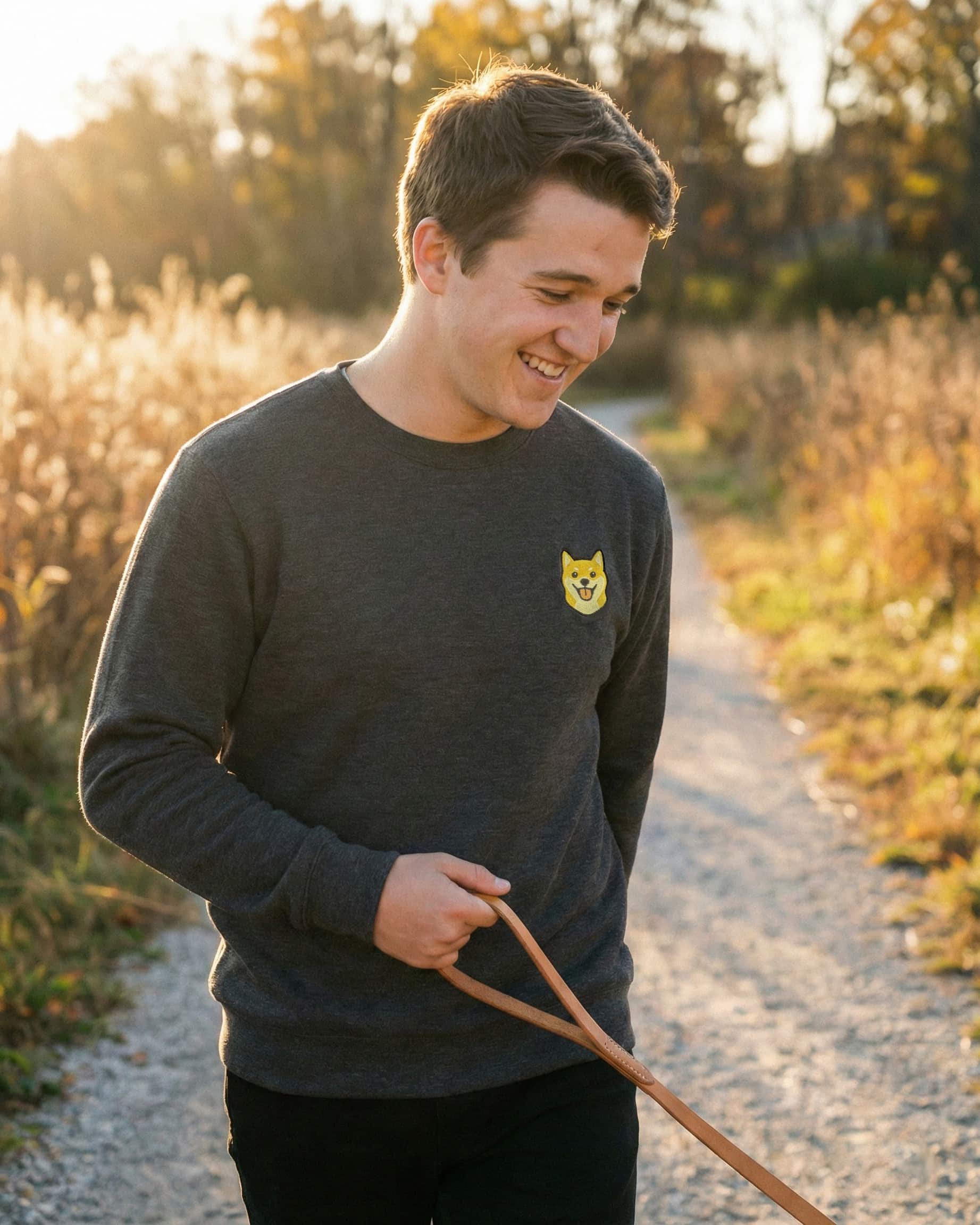 Man wearing Dark Grey Heather Sweatshirt with minimalist embroidered Shiba Inu icon on left chest.