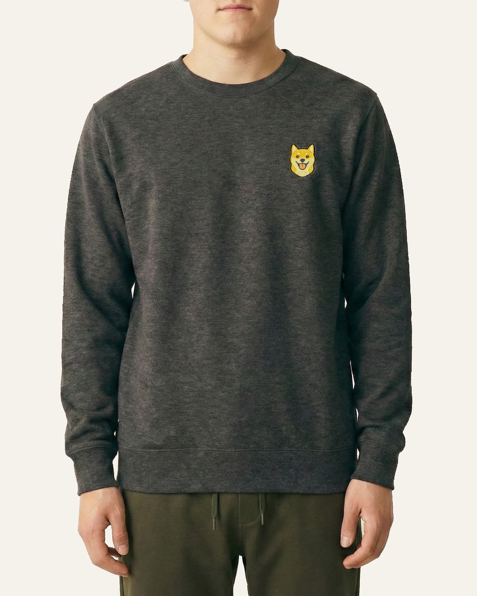 Man wearing Dark Grey Heather Sweatshirt with minimalist embroidered Shiba Inu icon on left chest.