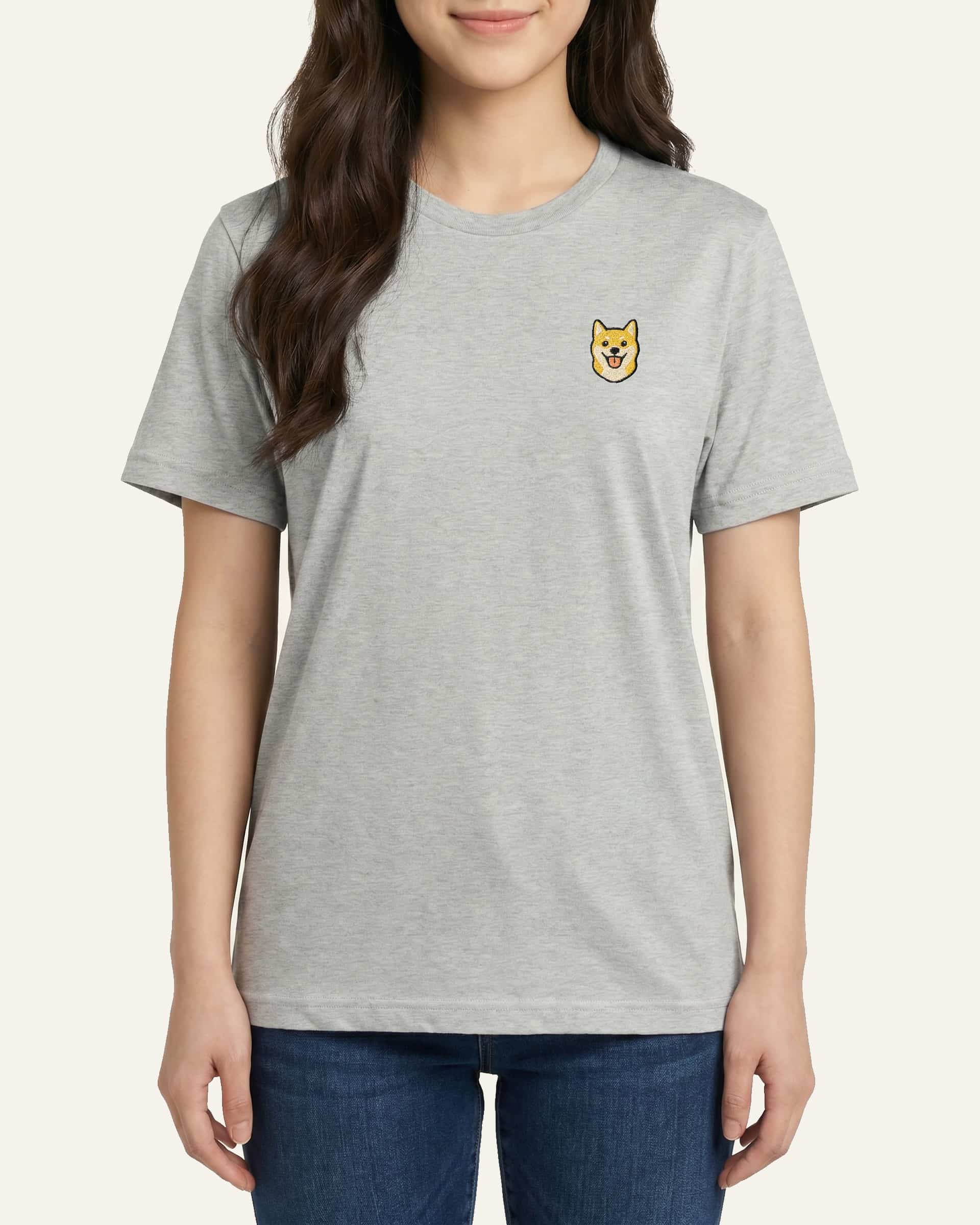 Woman wearing Light Grey Heather T-shirt with minimalist embroidered Shiba Inu icon on left chest.