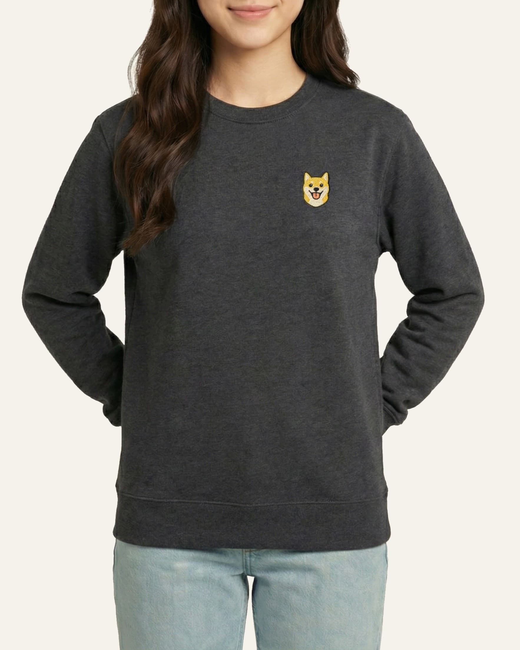 Woman wearing Dark Grey Heather Sweatshirt with minimalist embroidered Shiba Inu icon on left chest.