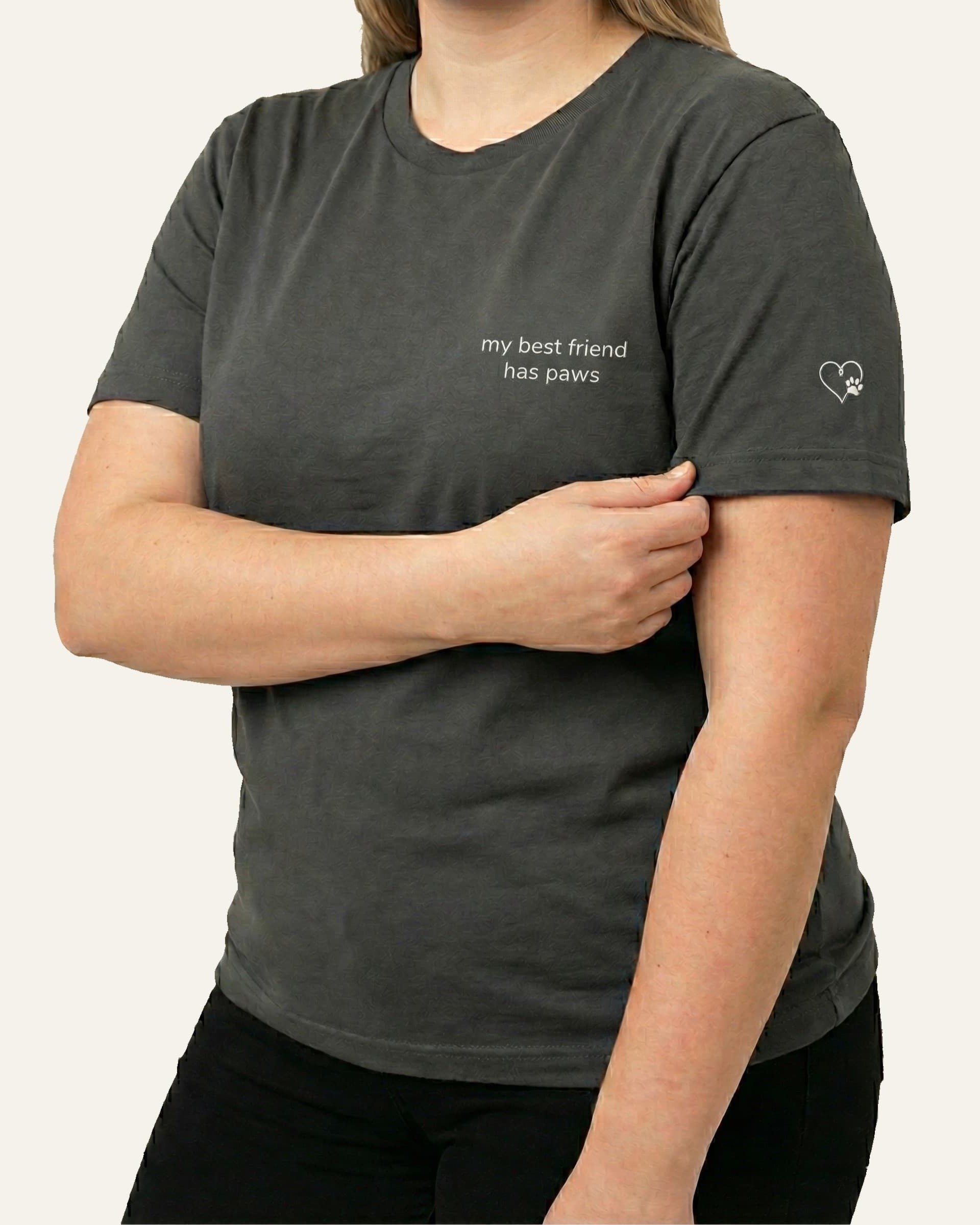 Woman wearing Asphalt t-shirt with minimalist embroidered phrase "my best friend has paws" on left chest. Embroidered Heart and Paw icon on the left sleeve above cuff.