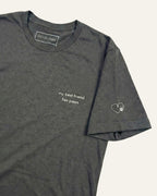 Asphalt t-shirt with minimalist embroidered phrase "my best friend has paws" on left chest. Embroidered Heart and Paw icon on the left sleeve above cuff.